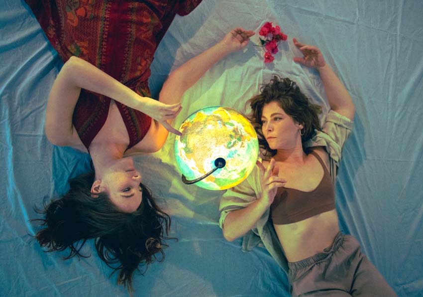 Dos mujeres tumbadas mirando un mapamundi